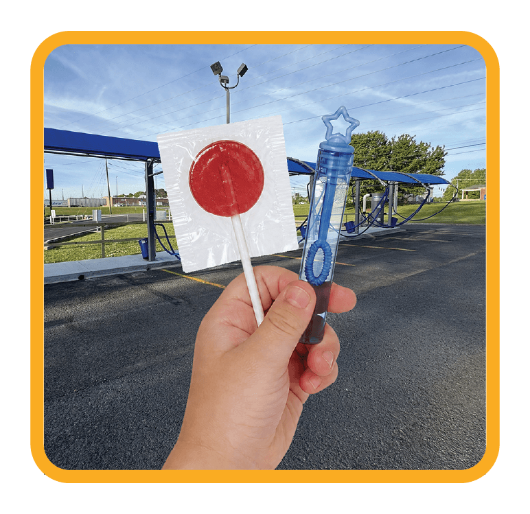 a child holding up a lollipop and a bubble wand